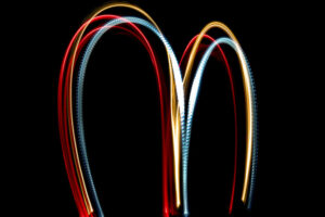 Letter M on a black background made with light painting torches